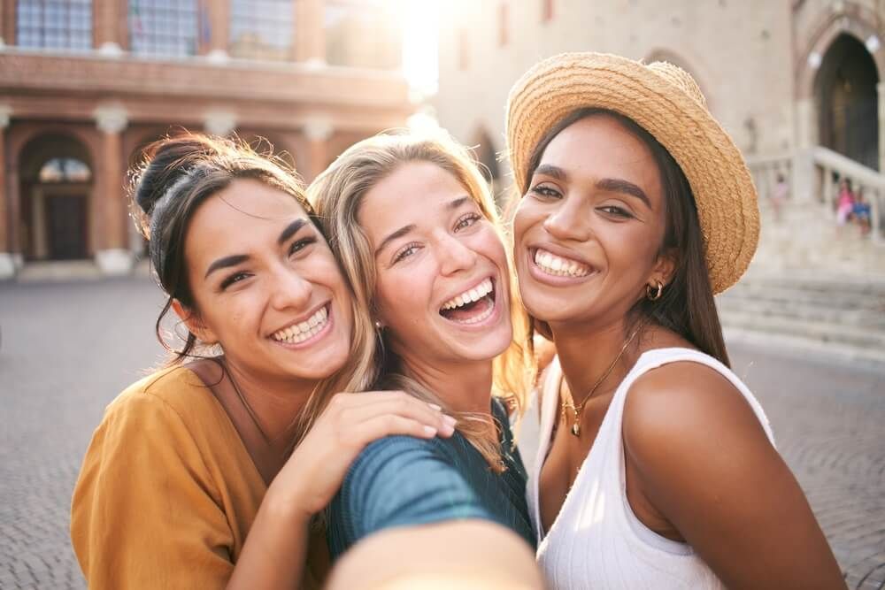 Three young smiling hipster women in summer clothes