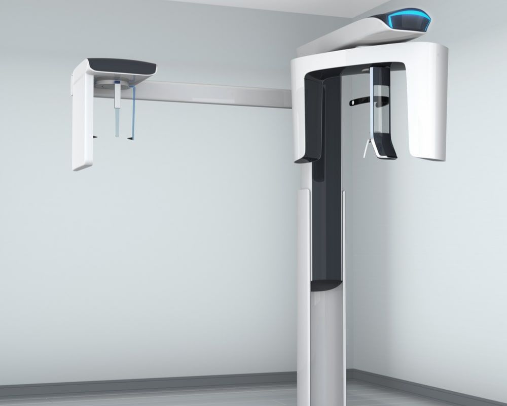 Dental CT scanner in clinic interior with cephalometric equipment.