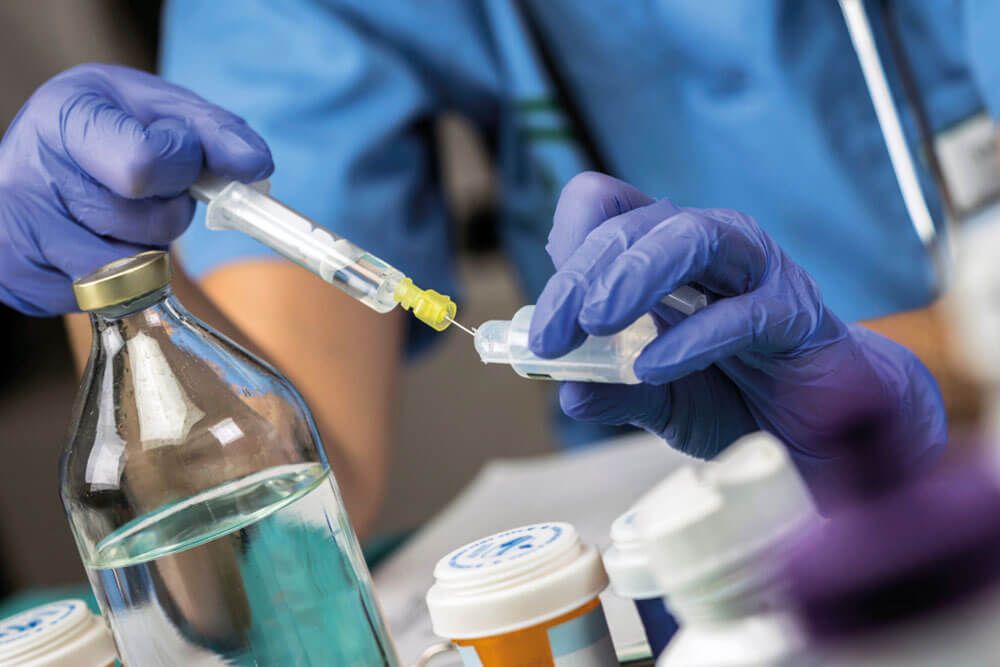 Nurse preparing medication for parenteral nutrition in a hospital