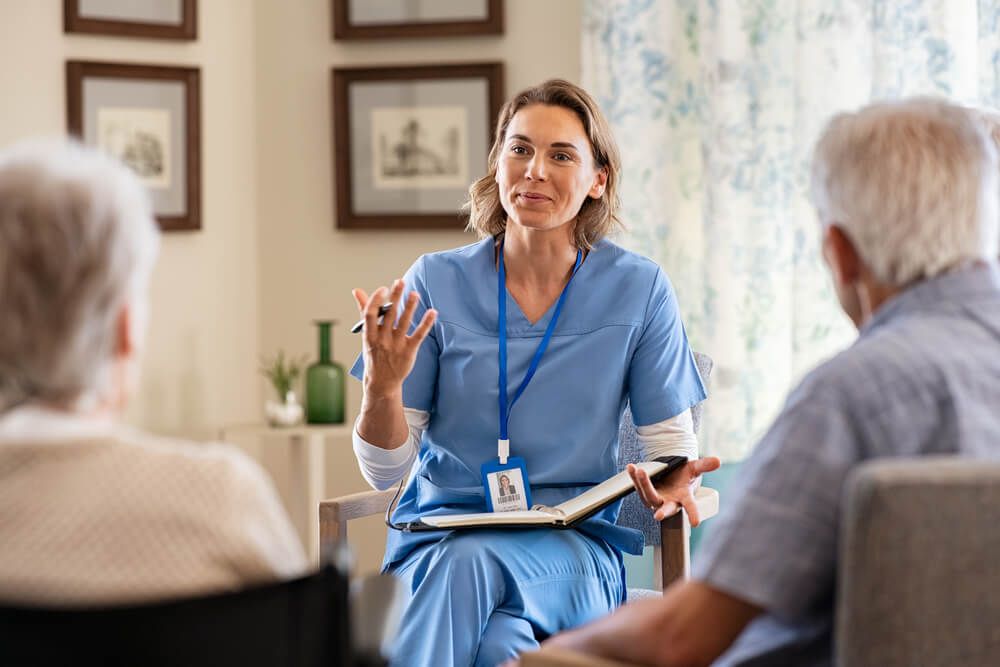 Nurse explaining to seniors at nursing home