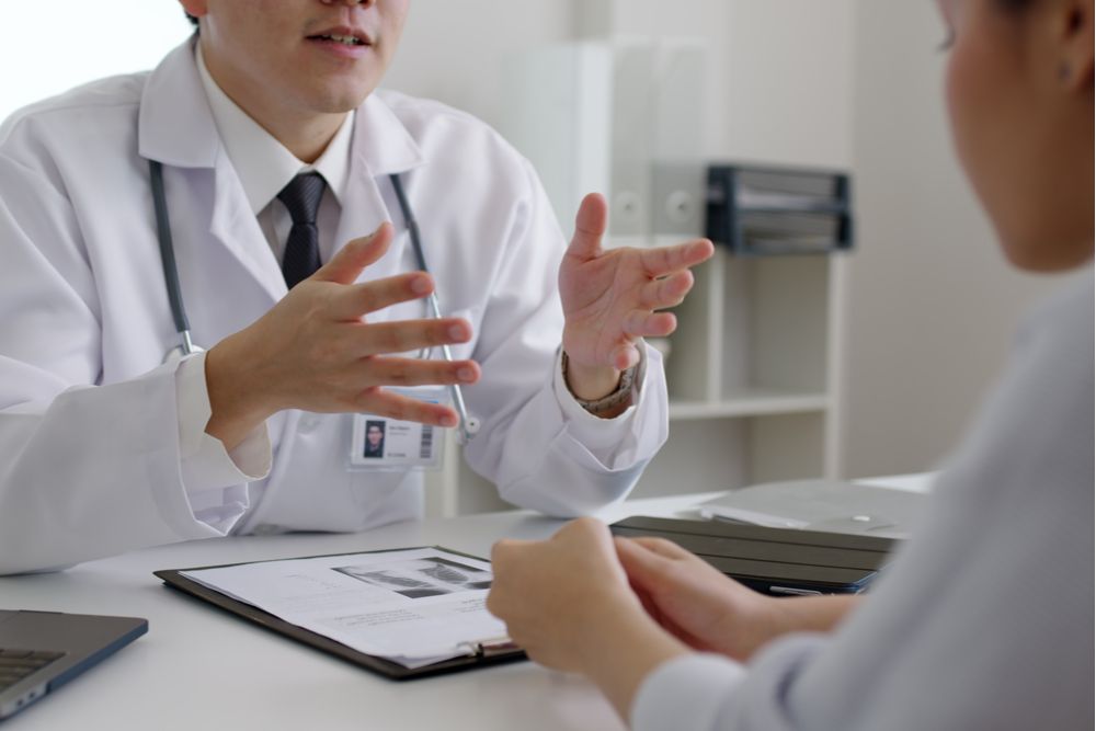 Friendly doctor discussing with female patient