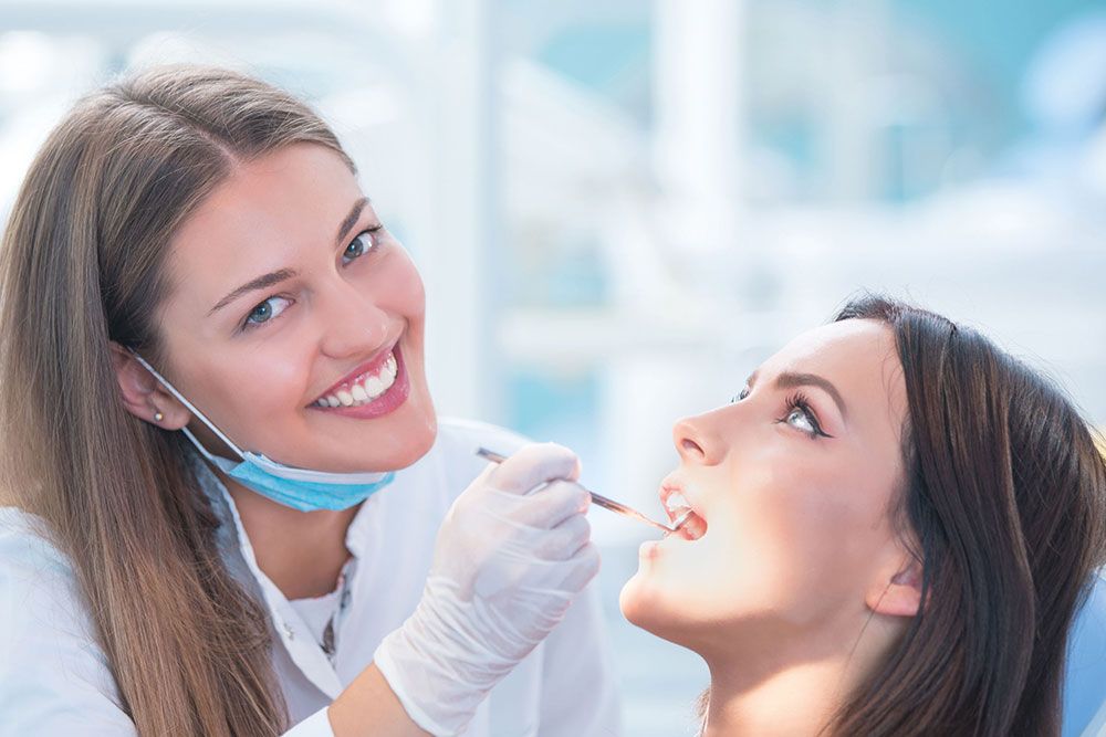 Dentist with smile checking patient