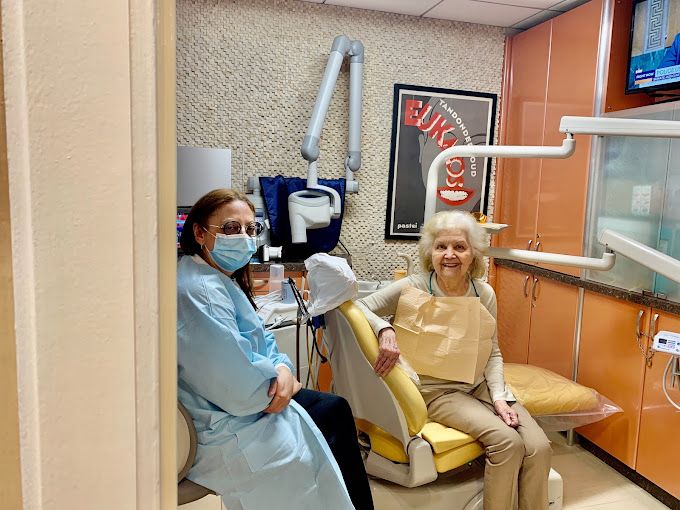 Doctor with happy patient in treatment room - Contemporary & Esthetic Dentistry