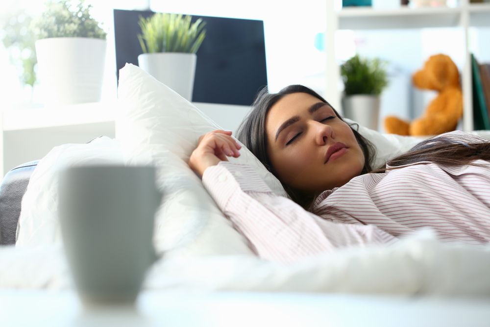 Woman peacefully lying in bed sleeping early morning