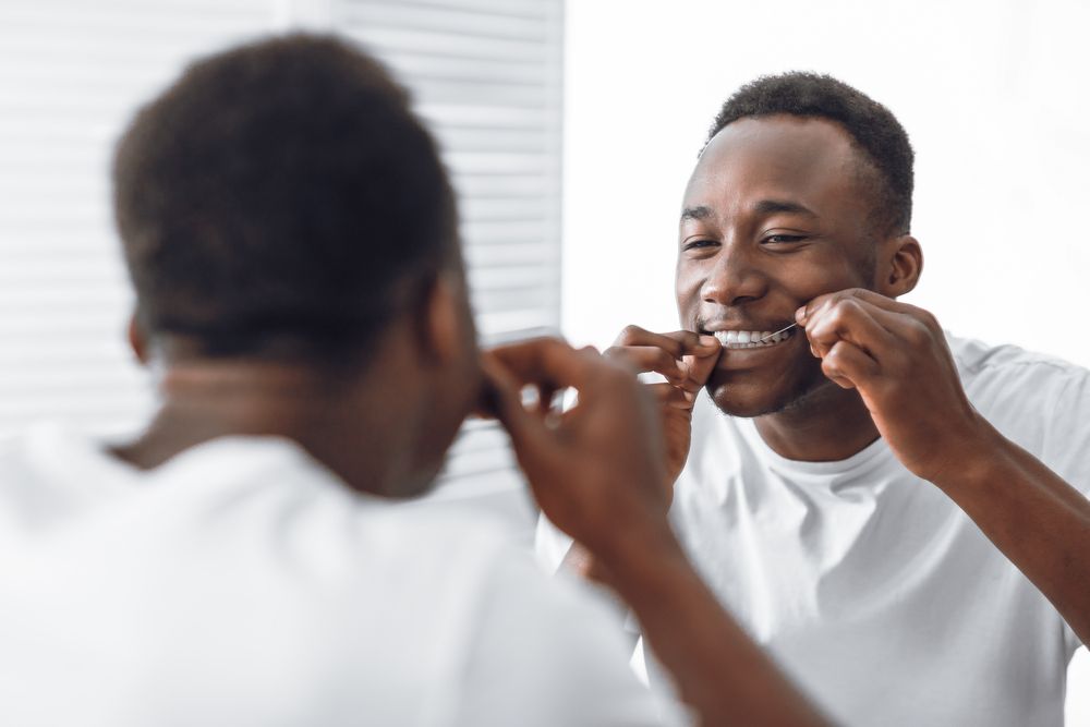 Man Flossing And Cleaning Teeth Using Tooth Floss