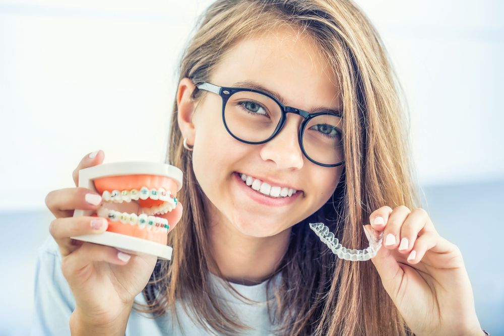 Dental silicone trainer in the hands of a young smiling girl