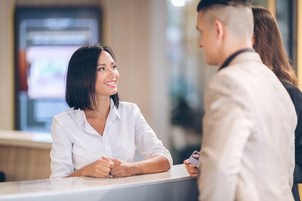 female receptionist at counter in clinic with Young couple