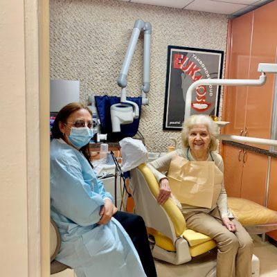 Doctor with happy patient in treatment room - Contemporary & Esthetic Dentistry