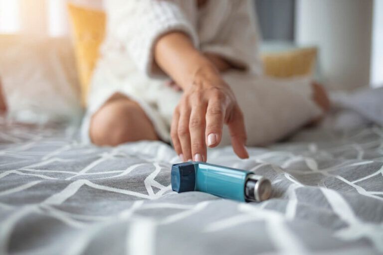 Asthmatic woman using an asthma inhaler