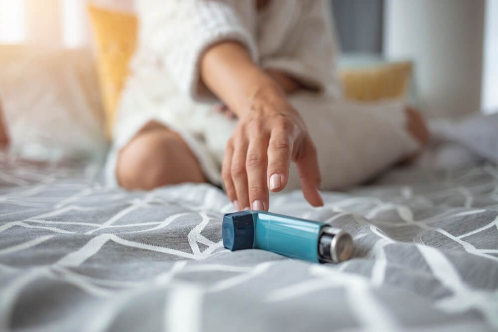 Asthmatic woman using an asthma inhaler