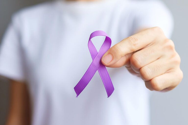 Hand holding purple Ribbon for Pancreatic
