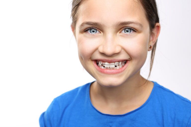 little girl with orthodontic appliance smiling