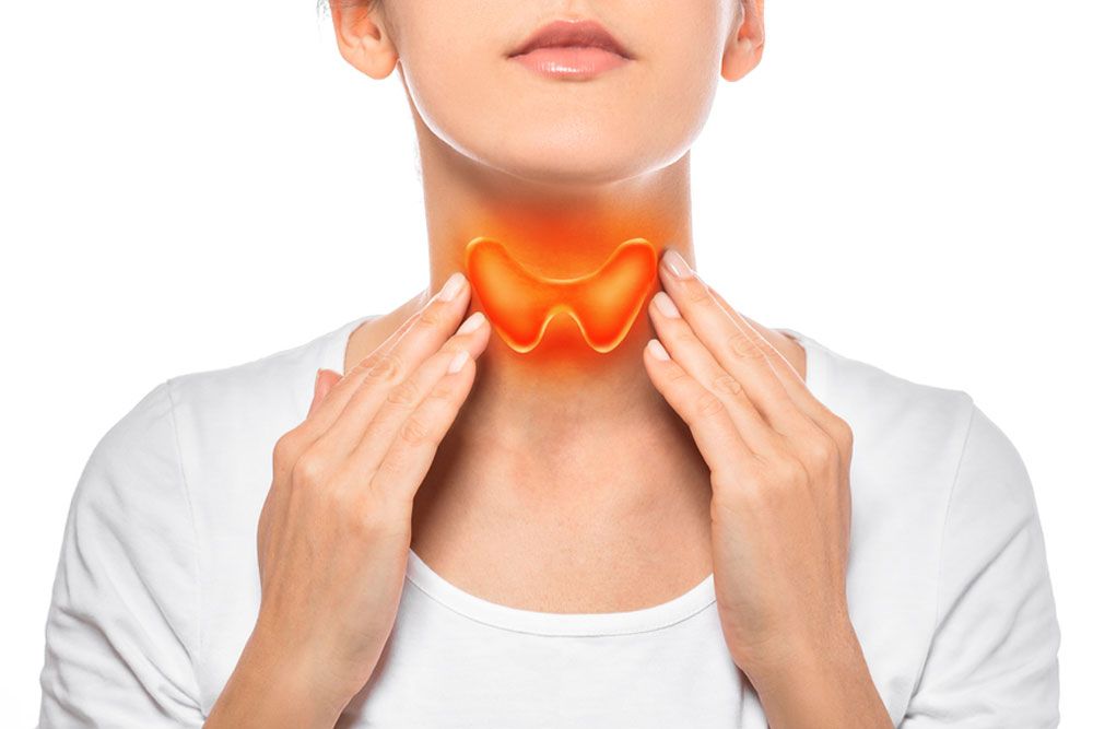 Woman showing painted thyroid gland on her neck