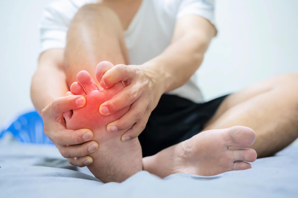 Man embrace foot with painful swollen gout inflammation