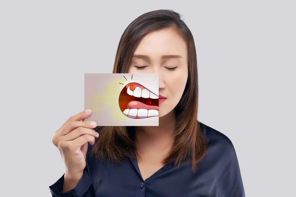 woman in the dark blue shirt having Oral Sores problem