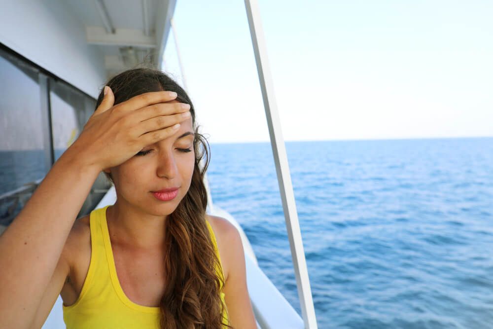Young woman suffer from seasickness during vacation on boat