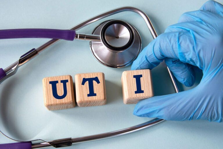 A hand in a medical glove puts cubes with the abbreviation UTI