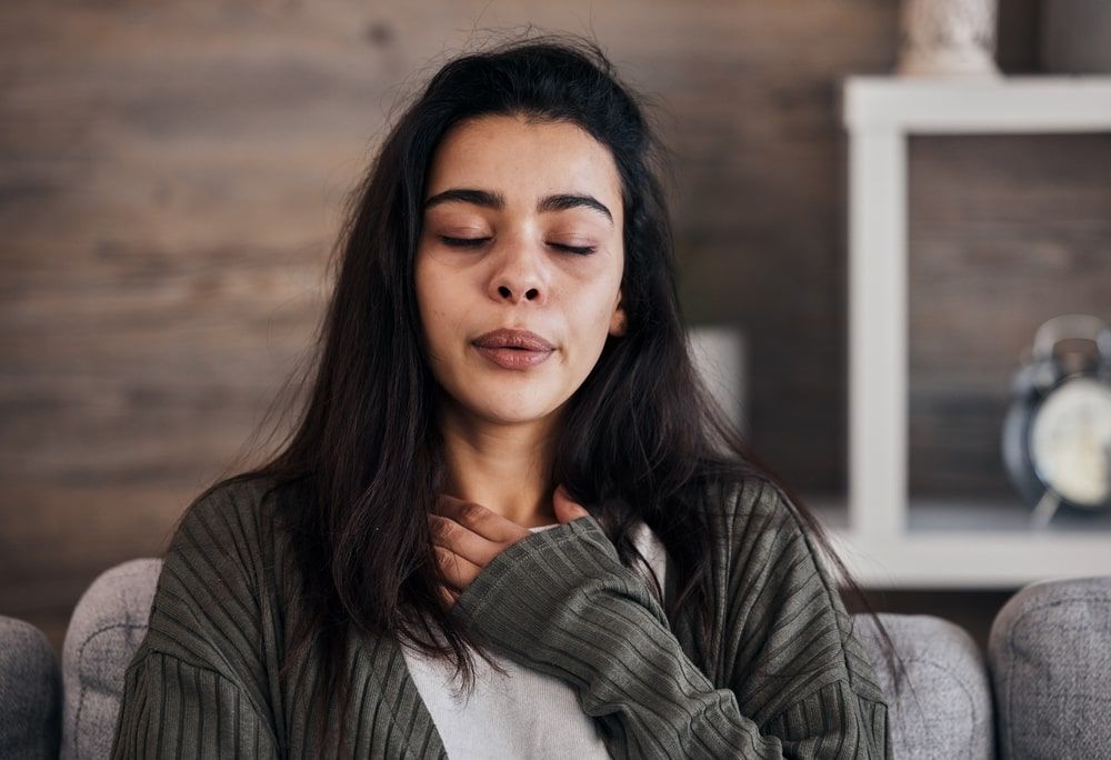 Woman with eyes closed in home thinking of problems