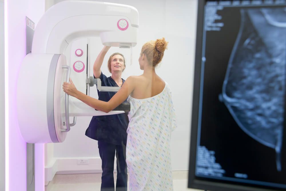 Radiographer is operating the mammogram system