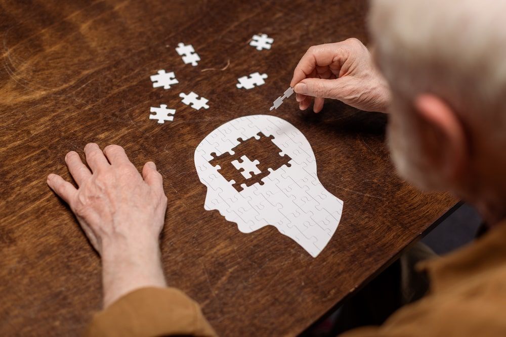 senior man collecting jigsaw puzzle