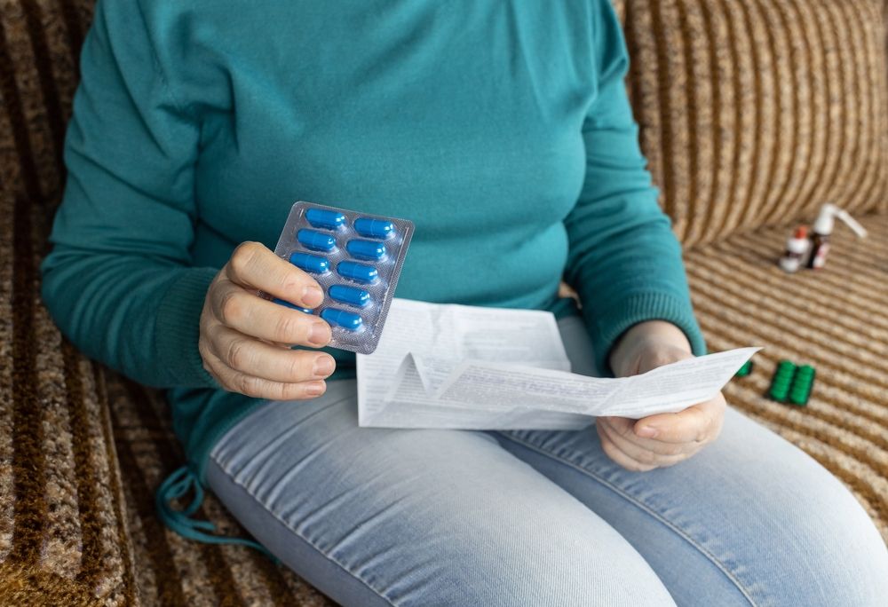 Senior woman reads instructions for medicines.