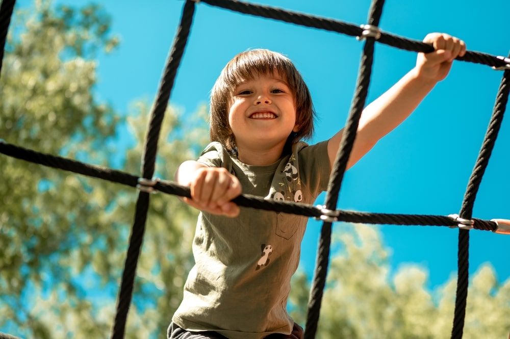 A child climbs up an alpine grid in a park