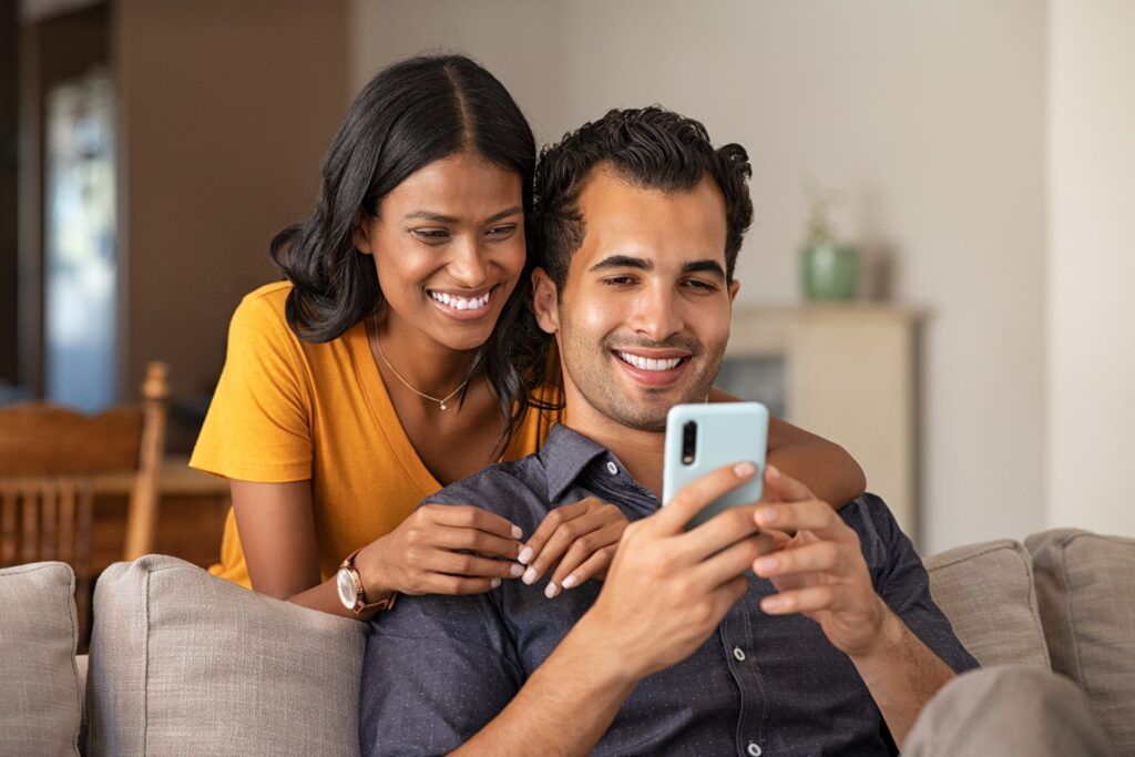 Couple using smartphone together at home