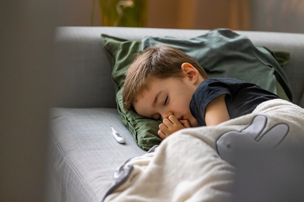 Unhealthy little boy child measure high temperature with thermometer