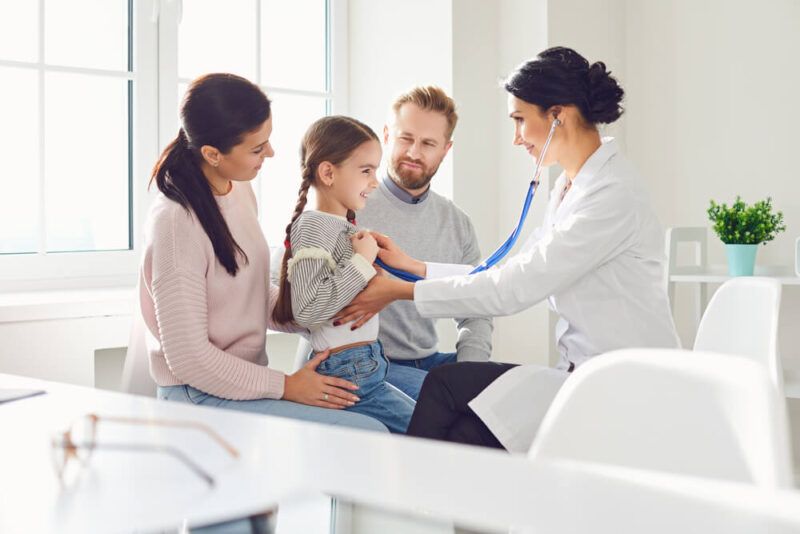 Happy family on a visit to the doctor in the office of a doctor