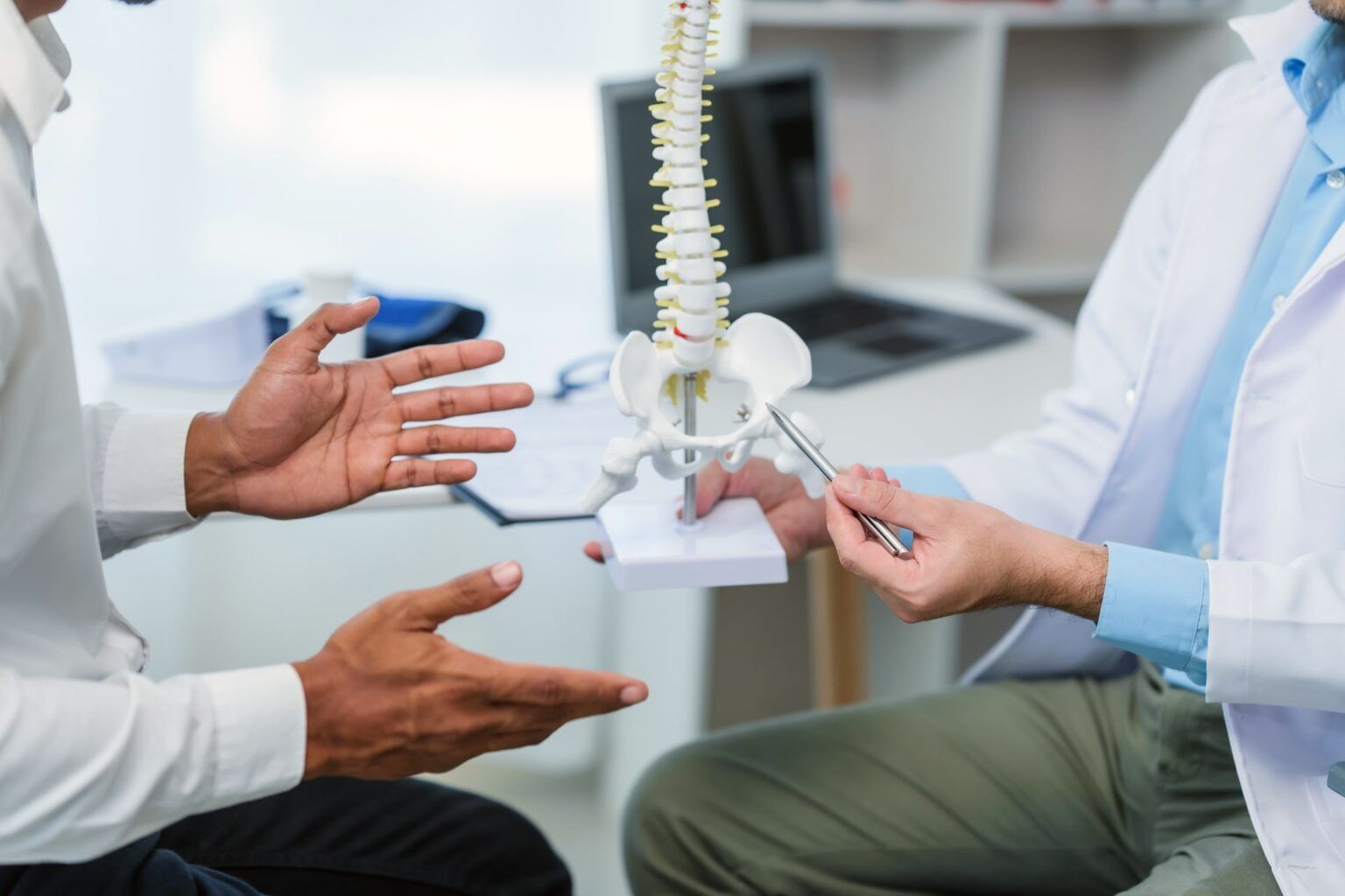 male doctor and patient people in a medical office, spine model
