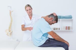 Doctor stretching a man back in medical office