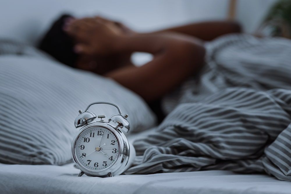 Woman suffering from insomnia lying in bed without sleep