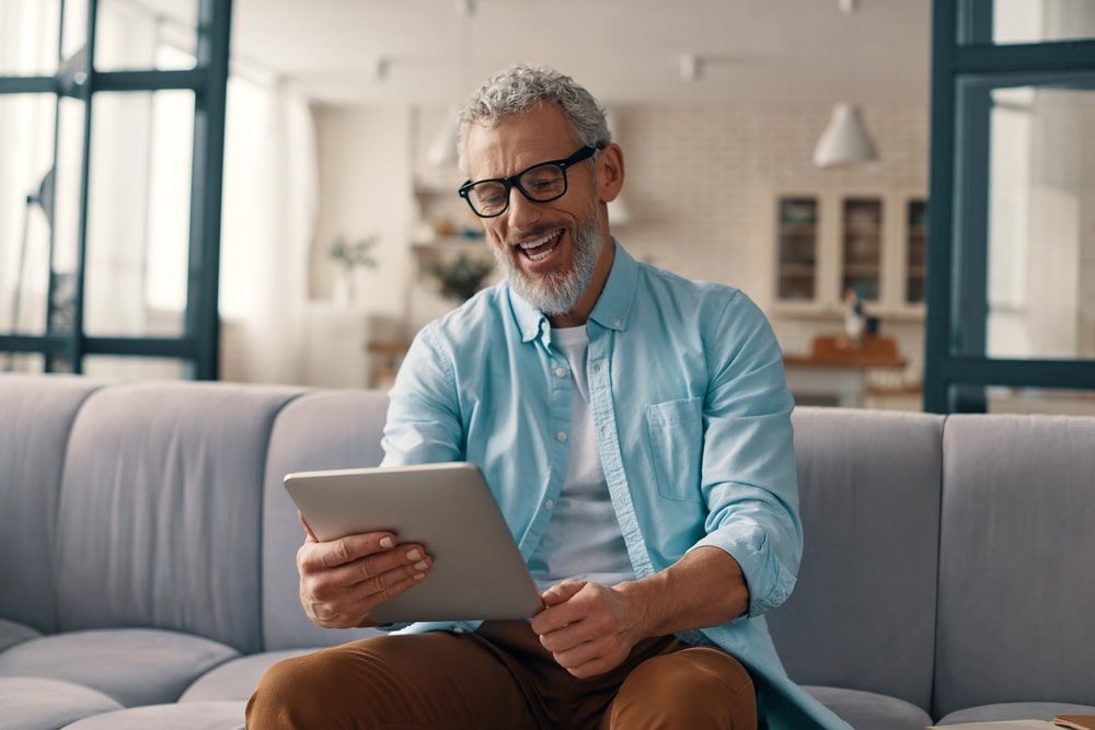 Relaxed senior man using digital tablet and smiling