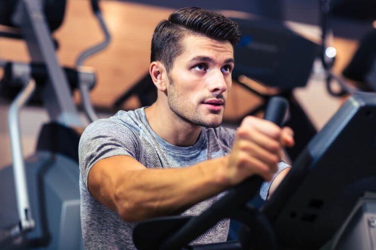 handsome man workout on a fitness machine at gym