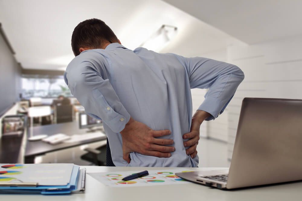 Business man with back pain in office