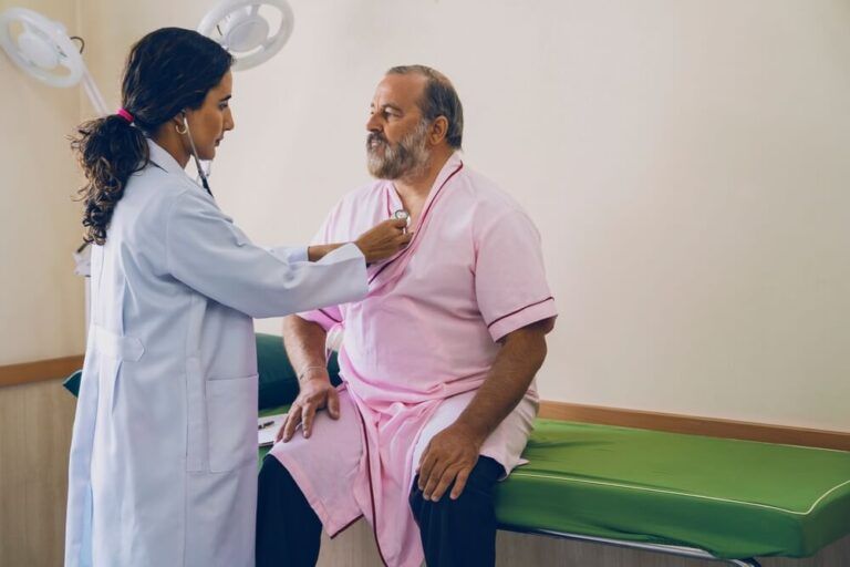 female doctor examining an elderly male patient