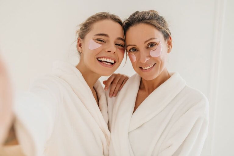 Happy caucasian mother with daughter wearing hydrogel patches smiling looking