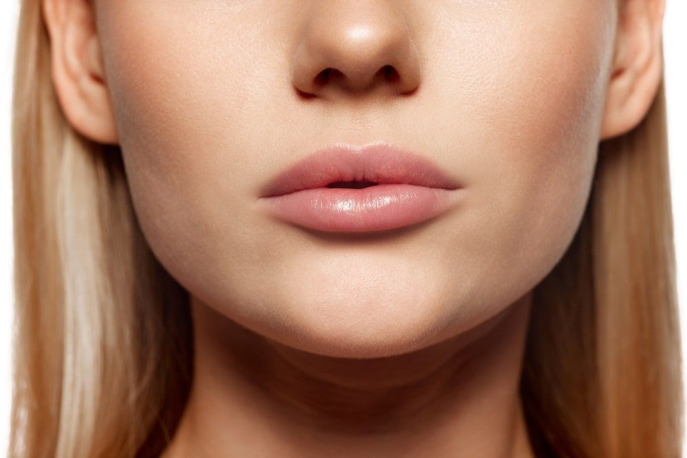 Plump, beautiful female lips. Close-up cropped image of female lower face part with well-kept skin and hydrated lips