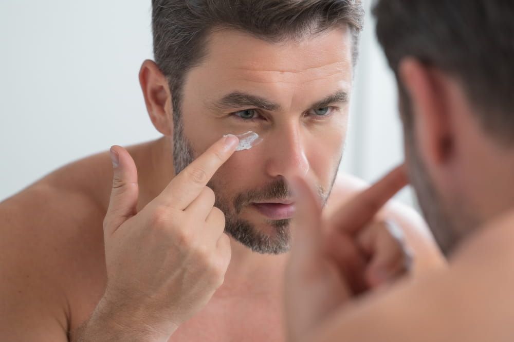 Male beauty. Cream treatment for male face. Beauty routine. Face of a beautiful man with perfect skin