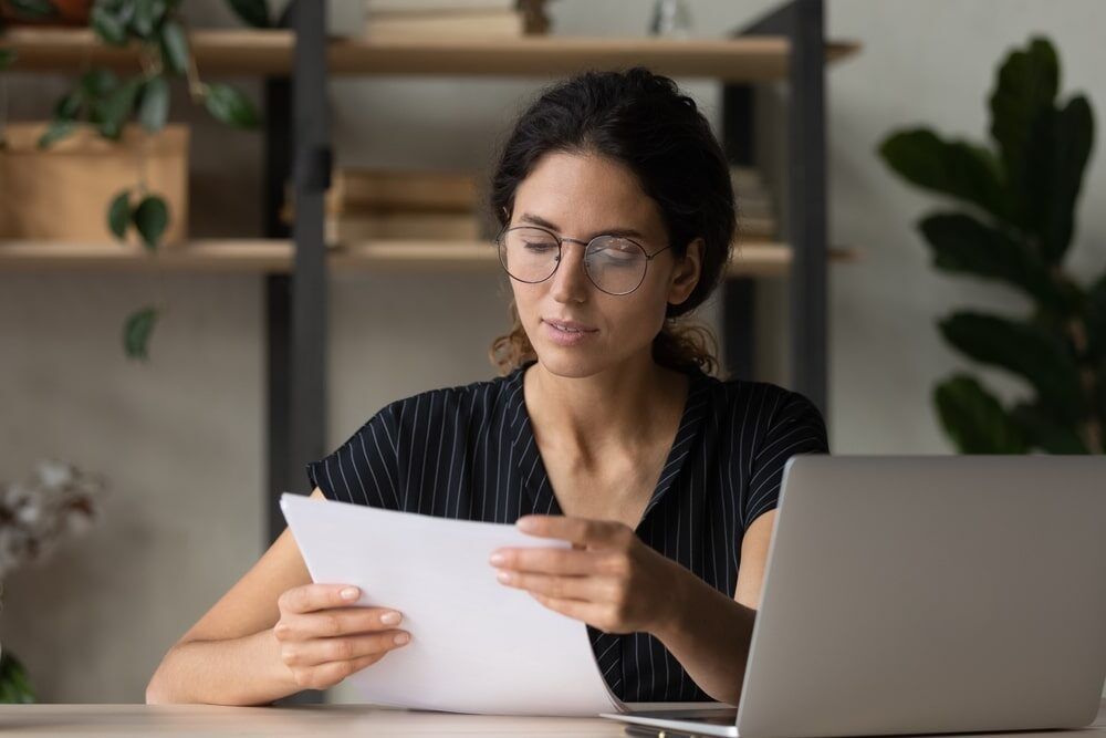 Female manager in glasses engaged in office paperwork