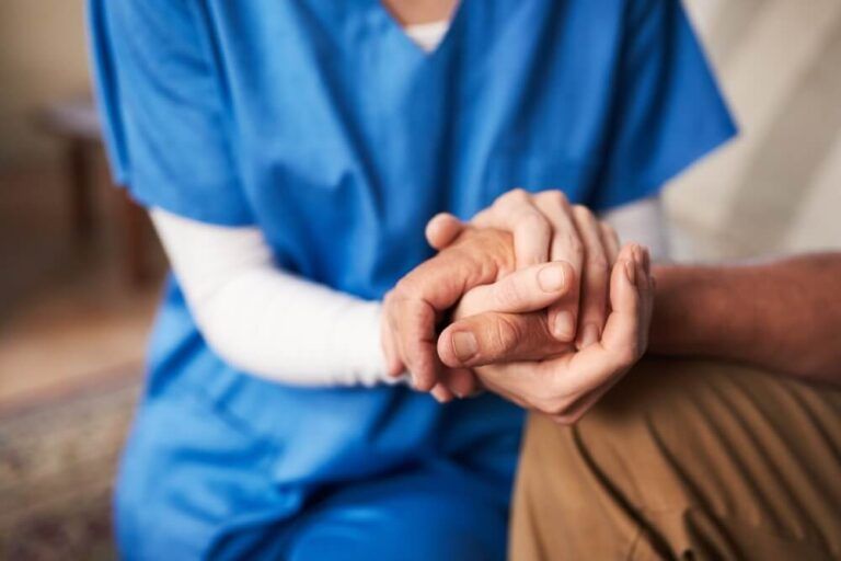 Youll never be alone again. Cropped shot of a female nurse hold her senior patients hand.