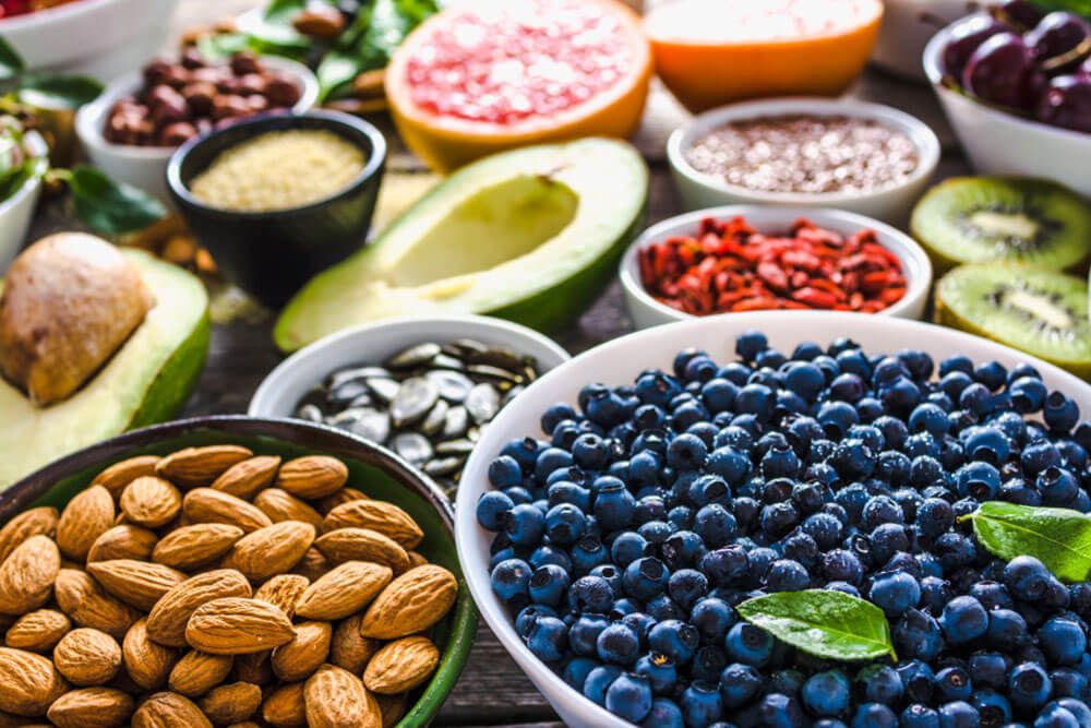 Bowl with almonds, bilberry, fresh fruit and other healthy food.