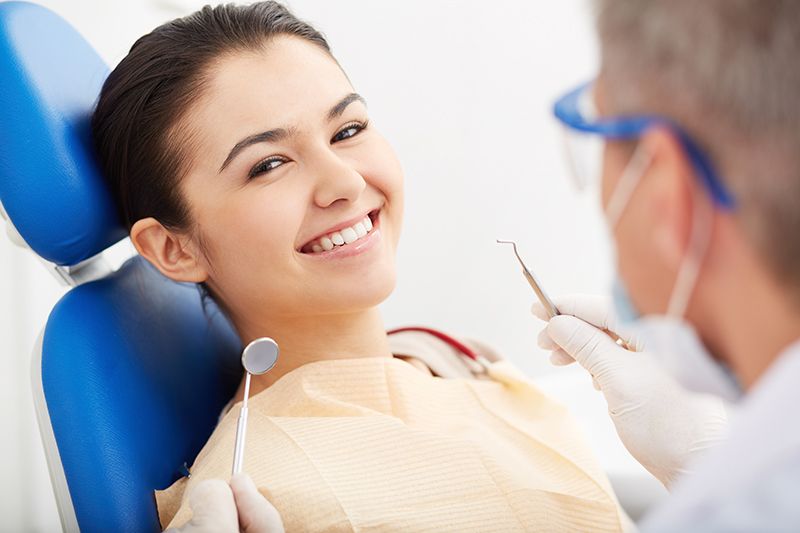 smiling patient at camera at the dentist