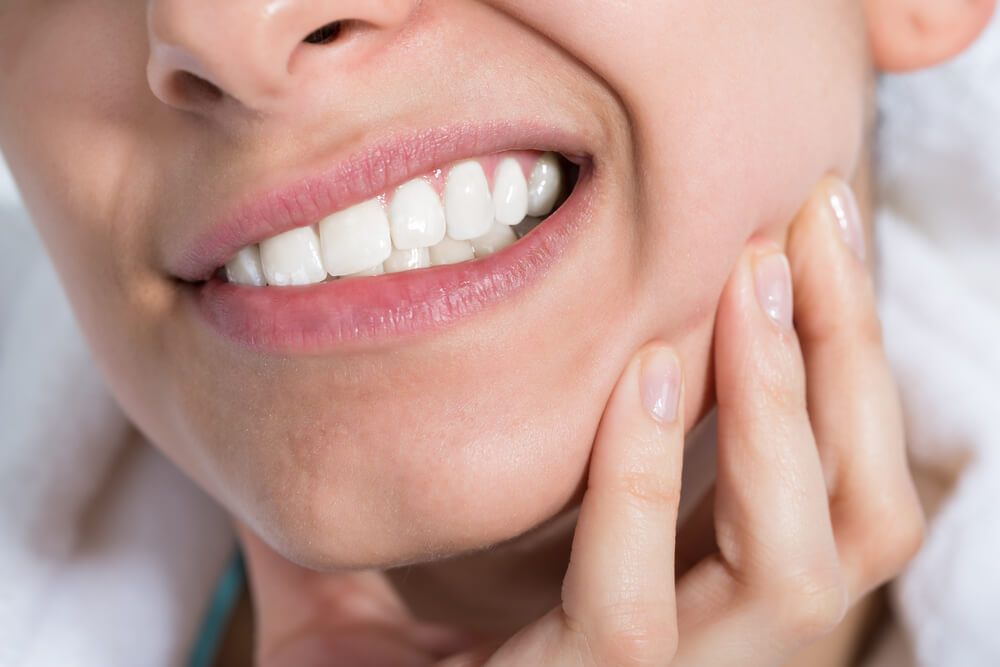 Closeup of young woman suffering from toothache at home