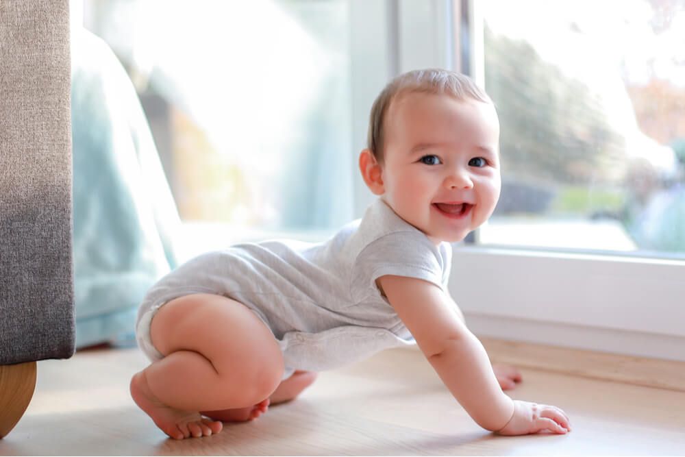 Cute baby boy with smiling face crawling on the floor