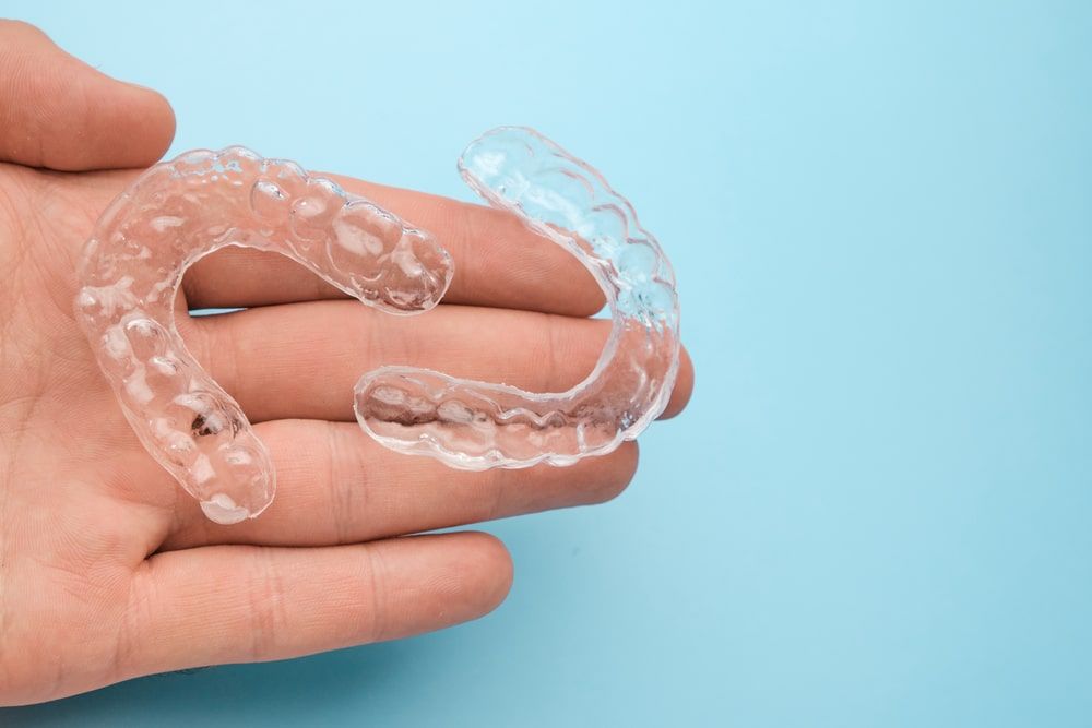 man hand holding invisible aligners
