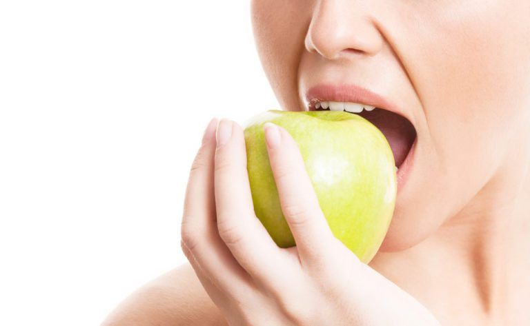 Girl eating fresh green apple
