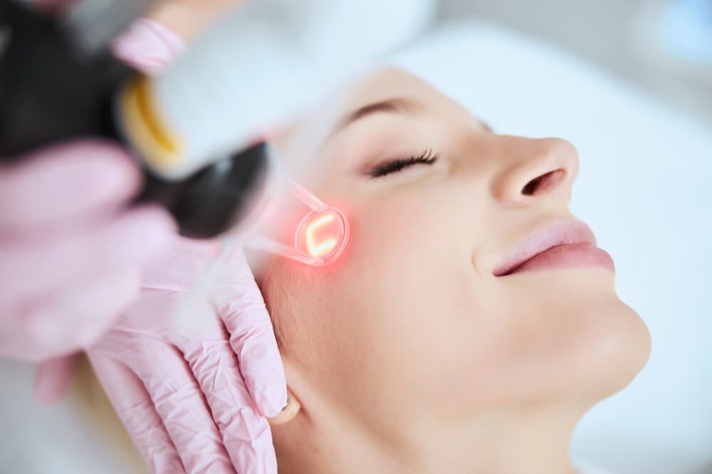 Young woman patient receiving a laser treatment in a spa salon