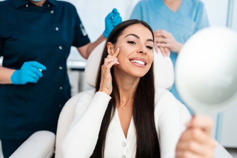 Beautiful and happy young woman sitting in medical chair and looking in the mirror