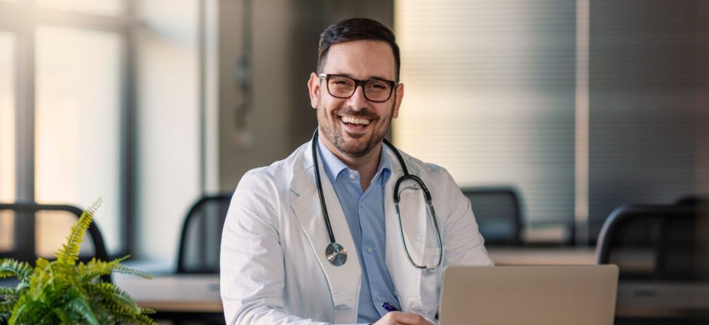 Doctor man sitting at the desk at his working place